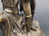 bronze figurine of a man and a woman with a dog