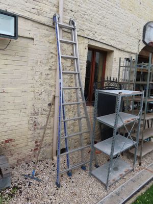 une échelle appuyée contre un mur de briques à côté d'un immeuble