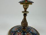a blue and gold candle holder on a white table
