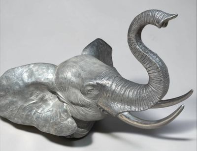 une tête d'éléphant en métal sur fond blanc