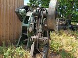 une machine qui se trouve dans l'herbe près d'un bâtiment