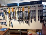 many skis hanging on the wall in the store