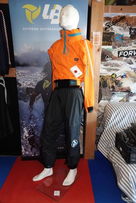 un mannequin vêtu d'une combinaison de ski, exposé devant une affiche