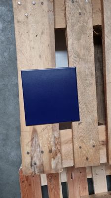 a blue box on a wooden pallet next to a wall
