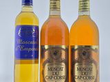 trois bouteilles de vin sont alignées sur une surface blanche