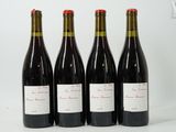 quatre bouteilles de vin sont alignées sur une surface blanche