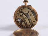 a close up of a pocket watch on a white surface