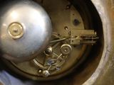 a close up of a silver clock with a metal ball
