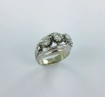 a close up of a diamond ring on a white surface