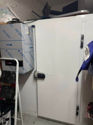 a white refrigerator in a room with a lot of clutter