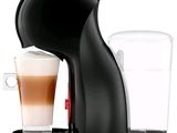 a black coffee maker with a glass of coffee next to it
