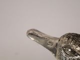 a silver bird that is sitting on top of a table