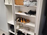many pairs of shoes on the shelves in the room