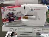une machine à coudre blanche exposée dans un magasin