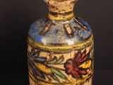 a small vase with a design on it on a black background
