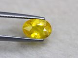 un gros plan d'un diamant jaune tenu par une paire de pinces