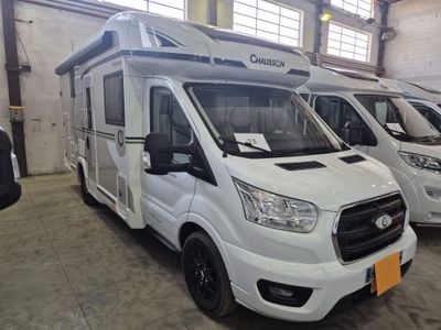 trois camping-cars blancs garés en rangée dans un garage