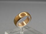 a close up of a gold ring on a clear stand