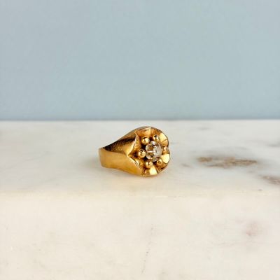 une image montrant un gros plan d'une bague en or posée sur une surface en marbre