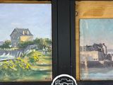 deux tableaux accrochés au mur d'une pièce où l'on voit les pieds d'une personne