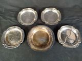 six silver plated dishes on a table with a black background
