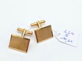 pair of gold plated cufflinks with a tag on a white background