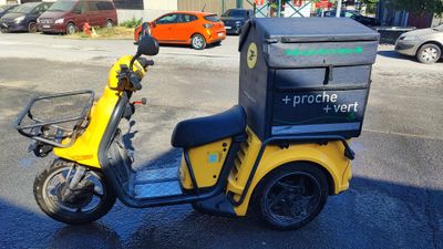 a yellow scooter with a box on the back of it