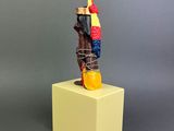 figurine of a native american man on a yellow pedestal
