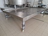 une grande table en acier inoxydable au milieu d'une cuisine