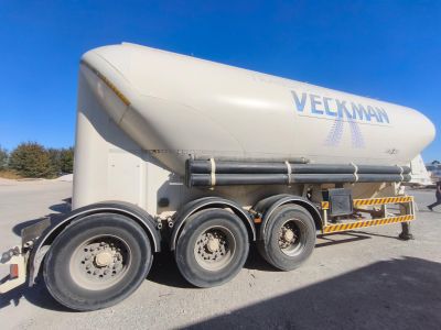 un gros camion-citerne blanc garé sur le bord de la route