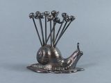 a silver sculpture of a snail with flowers in its shell