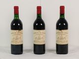 trois bouteilles de vin rouge sont alignées sur une table