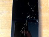 un téléphone portable cassé posé sur une table en bois