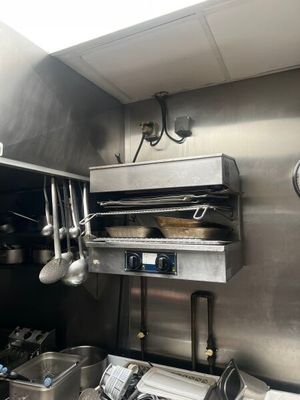 une cuisine en acier inoxydable avec des casseroles et des poêles suspendues au plafond