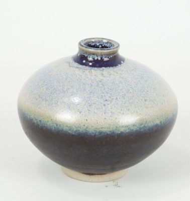 un vase bleu et blanc posé sur une surface blanche