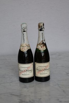 two bottles of champagne sitting on a marble table
