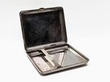 a small metal box with a pair of scissors inside of it
