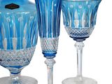three wine glasses and a decanter sitting next to each other