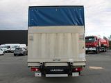 trucks parked in a parking lot with a blue tarp on the back of the truck
