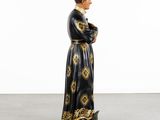 a figurine of a man in a black and gold robe