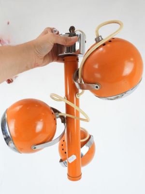 une personne tenant une lampe orange fixée à un poteau
