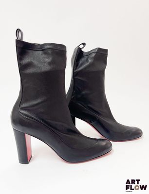 des bottines en cuir noir à semelles rouges sur fond blanc