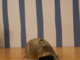a statue of a turtle on a wooden table next to a vase