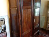 une grande armoire en bois dans le coin d'une pièce