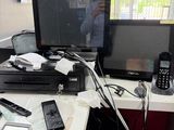 un bureau sur lequel se trouvent de nombreux appareils électroniques et un téléphone