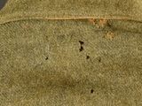 a close up of a green uniform with holes in it