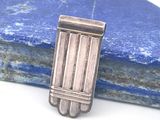 une épingle plaquée argent ornée de barrettes, posée sur une pierre bleue