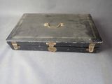 a black suitcase with a gold handle sitting on a white surface