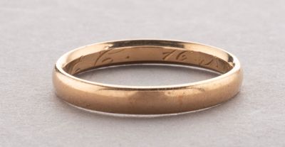 a close up of a gold wedding ring on a table