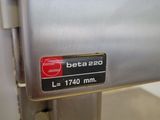 a close up of a metal object with a red button